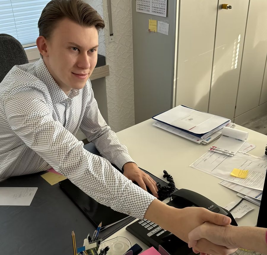 Beratung im Büro der Rheinland Immobilien Makler OHG – Handschlag über dem Schreibtisch